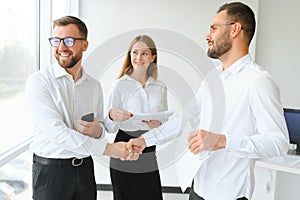 Happy successful multiracial business team giving a high fives gesture as they laugh and cheer their success.