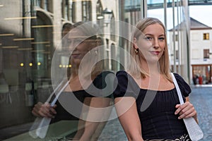Happy successful professional posing near office building. Young blonde caucasian business woman standing outside