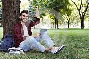 Happy successful student with arm raised in he air