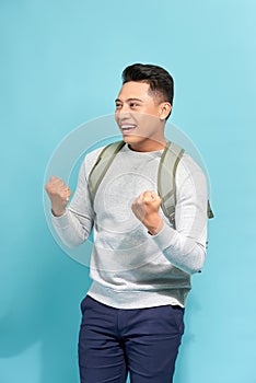 Happy successful student, business man winning, fists pumped celebrating success isolated blue background
