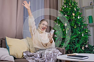 Happy successful woman with hand up celebrating victory while reading e-mail on mobile phone