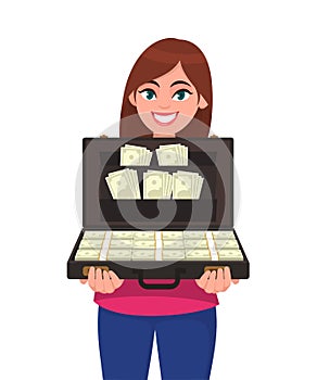 Happy successful young woman holding briefcase full of money banknotes. Businesswoman holds up a suitcase full of currency notes.