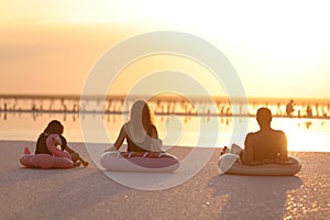Happy summer family vacation. Silhouette of Mom, Dad and child daughter having fun together on seashore and sitting in