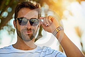 Happy, sunglasses and portrait of a man in an outdoor park while on a summer vacation, adventure or holiday. Smile
