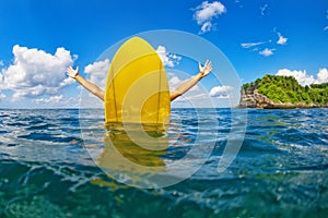 Happy surfer girl sit on yellow surfboard in ocean