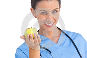 Happy surgeon holding an apple and smiling