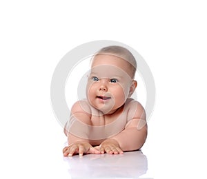 Happy, surprised, amazed infant child baby girl kid in diaper is lying on her stomach holding arm outstretched