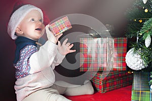 Happy surprised baby holding gift box, present, Christmas, eve