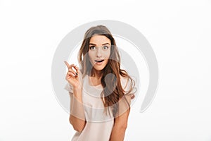 Happy surprised brunette woman in t-shirt having idea