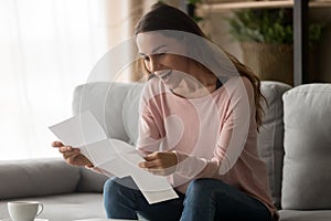 Happy surprised millennial lady reading last payment bank loan document.