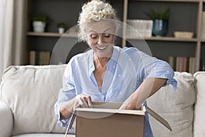 Happy surprised online shop customer woman opening parcel