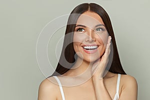 Happy surprised woman spa model with clear skin and long healthy straight hair. Skincare and facial treatment concept