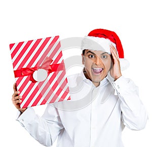 A happy and surprised young man in santa's hat