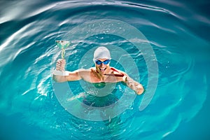 Happy swimmer with goblet and medal