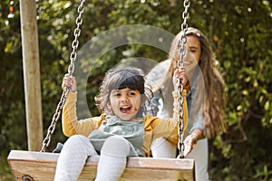Happy, swing and mother and child in park for playing, bonding and having fun together outdoors. Nature, weekend and mom