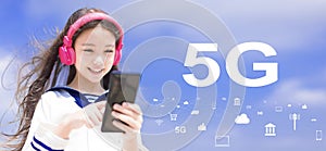 Happy syudent girl  listening music in headphones and holding mobile phone with 5G network concepts