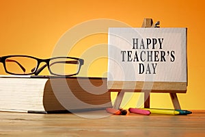 HAPPY TEACHER`S DAY CONCEPT: School stationeries over a orange b photo