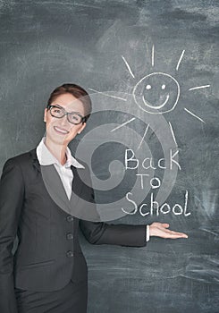 Happy teacher and smiling sun on the chalkboard