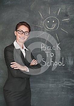 Happy teacher and smiling sun on the chalkboard