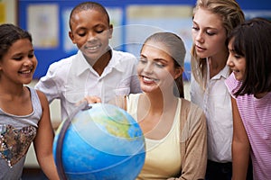 Happy teacher, students and globe of earth in class for education, learning or geography at school. Woman, mentor or