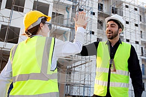 Happy team of architect or engineer with success and glad while hi five together at construction site.