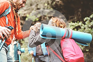 Happy team friends doing trekking excursion on mountains - Group young tourists hiking and exploring the wild nature