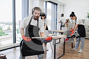 Happy team of people in black aprons cleaning modern office.