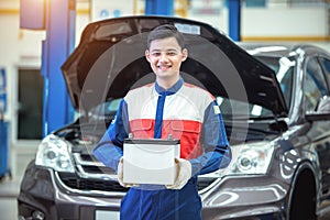 Happy technician or auto mechanic Reassuring the car battery in auto repair car service center