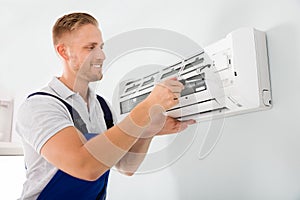 Happy Technician Repairing Air Conditioner