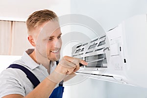 Happy Technician Repairing Air Conditioner