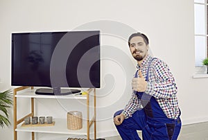 Happy technician showing thumbs up after he has repaired or installed television set