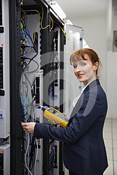 Happy technician using digital cable analyzer on server