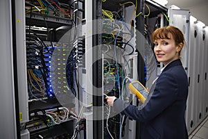 Happy technician using digital cable analyzer on server