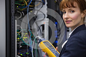 Happy technician using digital cable analyzer on server