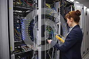 Happy technician using digital cable analyzer on server