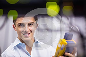 Happy technician using digital cable analyzer on server