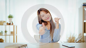 Happy teen asian girl blogger smiling face waving hand talking to webcam recording vlog