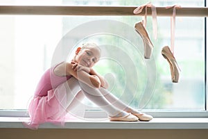 Happy teen ballet girl sitting on windowsill.
