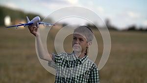 Happy teen boy playing with toy airplane on nature