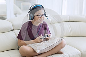 Happy teen boy playing video games with a joystick
