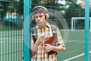 Happy teen boy portrait on the way to school, he is eating an apple, education and back to school concept