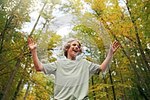 Happy Teen Boy Smiling as He Hikes in the Autumn Woods