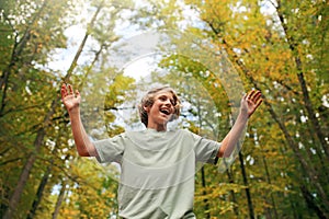 Happy Teen Boy Smiling as He Hikes in the Autumn Woods photo