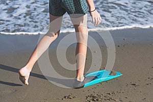 Happy teen boy in the swim flippers having fun on the sand Ð¾n the beach