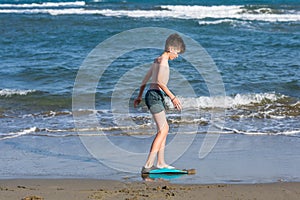 Happy teen boy in the swim flippers having fun on the sand Ð¾n the beach