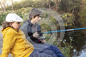 Happy teen boys go fishing on the river, children of the fisherm