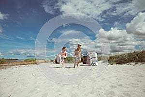 Happy teen children joyful playing on white beach at summer holidays