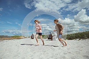 Happy teen children running and having fun on beach  at summer holidays