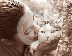 Happy teen girl with cat close up sepia black and white portrait on summer garden background