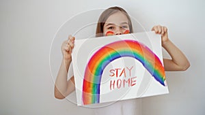 Happy teen girl drew rainbow and poster stay home.